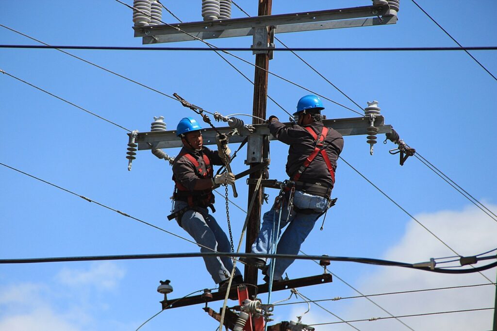 wire telephone poles with maintenance workers